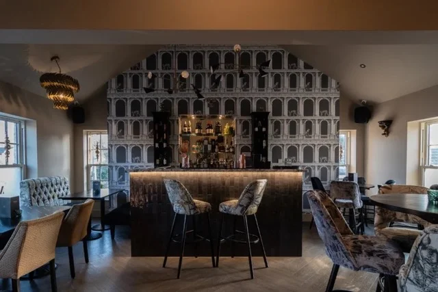 The private events room, with the bar and patterned stools under a feature chandelier